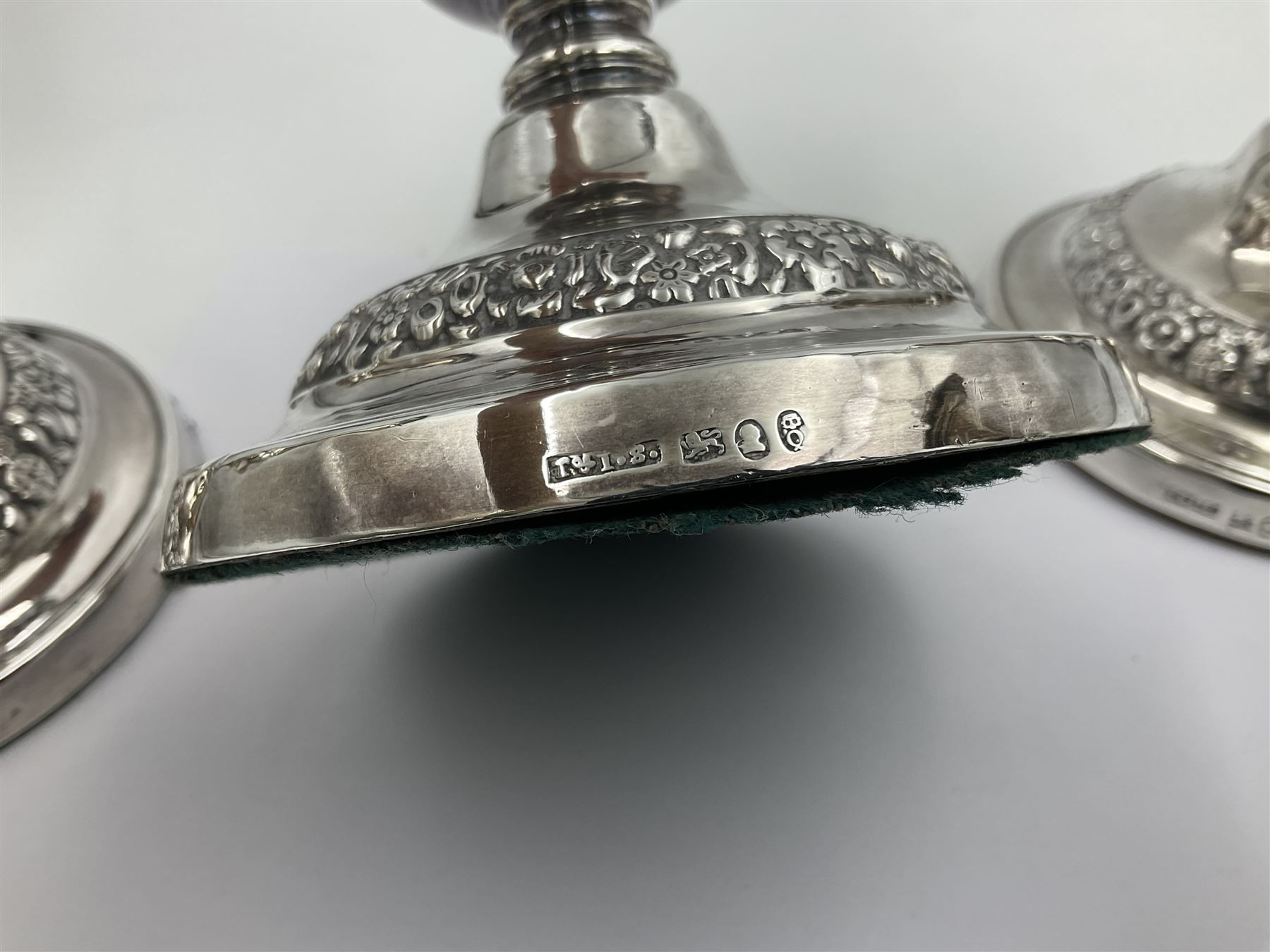 Four George III silver candlesticks, each upon knopped stem and weighted circular stepped foot, the foot and removable sconce repousse decorated with a band of flower heads, hallmarked to sconce and foot Thomas & John Settle, Sheffield 1820, H17.5cm