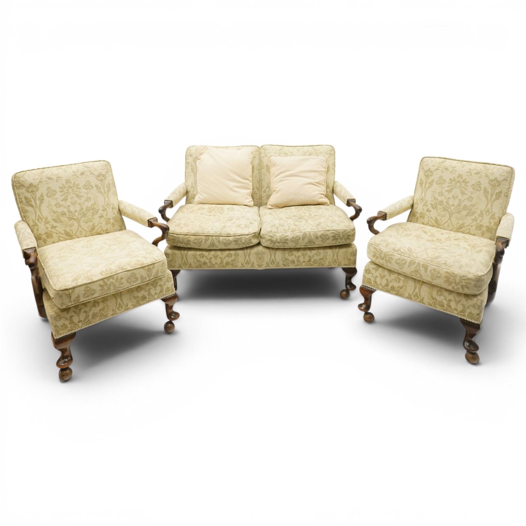 George II design mahogany framed three-piece salon suite, comprising settee and two armchairs, with pale green floral patterned upholstery, scroll carved arm terminals, loose cushioned seats and backs, raised on cabriole supports terminating in castors
Armchairs (H 80cm, W 62cm, D 73cm)