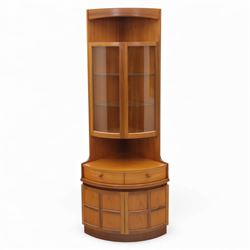 Nathan for Parker Knoll - corner cabinet, the upper section enclosed by two curved glazed doors with glass shelves, over a shaped base fitted with a single frieze drawer and panelled twin cupboard doors