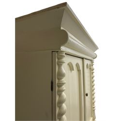 Victorian cream painted pine cupboard-on-chest or housekeeper's cupboard, projecting cornice over two double-arch panelled cupboard doors enclosing two shelves, flanked by spiral turned uprights, base fitted with two short over two long drawers, on bun feet