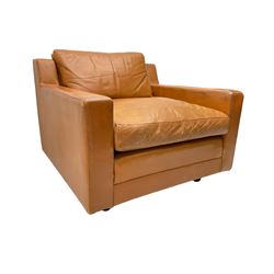 Mid-20th century armchair, upholstered in tan leather with loose cushions, on castors