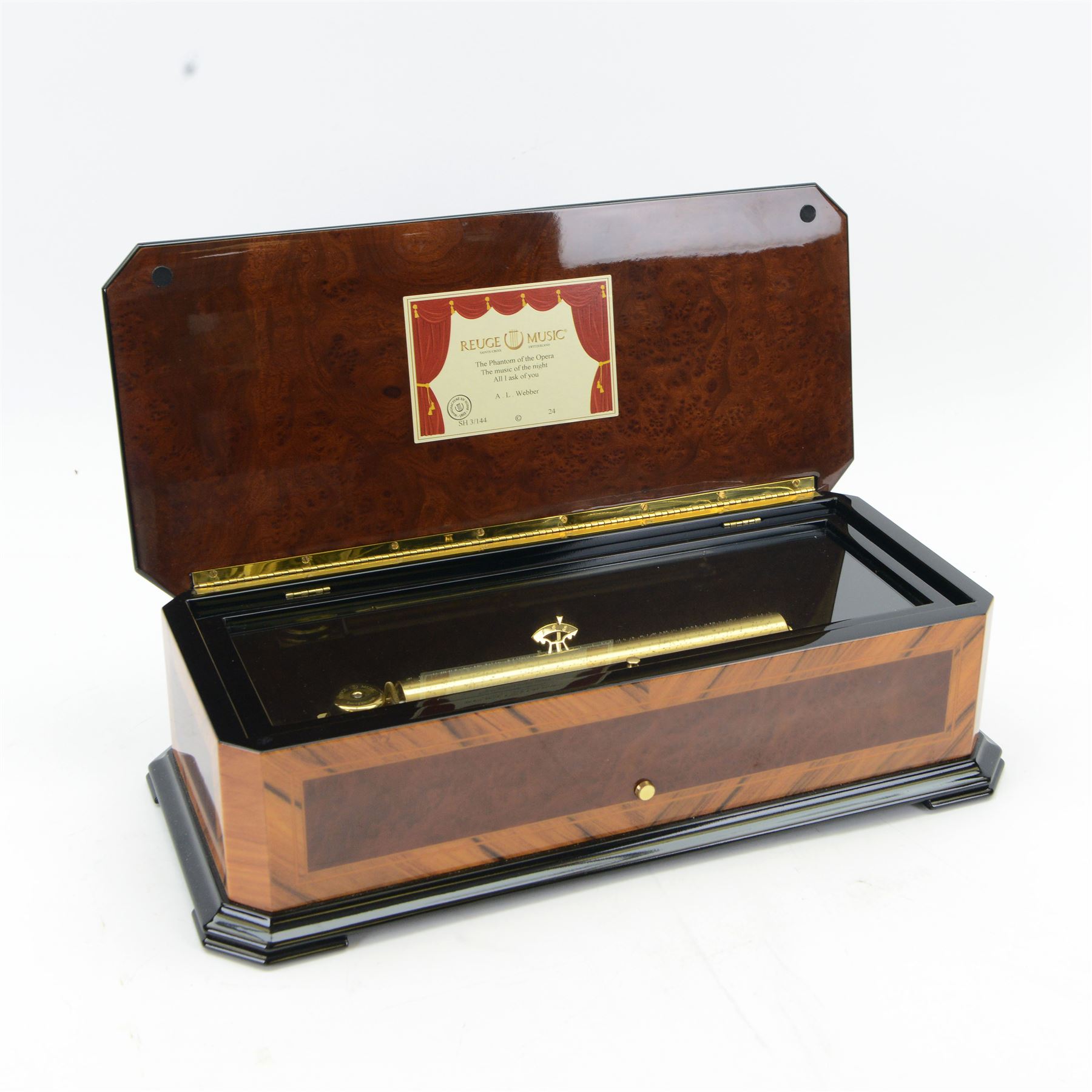 Reuge Sainte-Croix- 21st century Swiss musical box with a highly polished lacquered finish, inlaid and ebonised case with a glazed internal viewing lid, polished steel 144 teeth two-part comb playing three arias from The Phantom of the Opera by Lloyd Webber, with tune indicator and tune sheet.