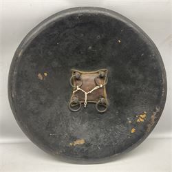 Indian black lacquered hide shield/dhal, of circular convex form with strongly outward-turned brim, fitted at its centre with four metal bosses, each of hemispherical form, with traces of silvered foliate decoration, the bosses corresponding on the inside with four iron rings for enarmes D49cm