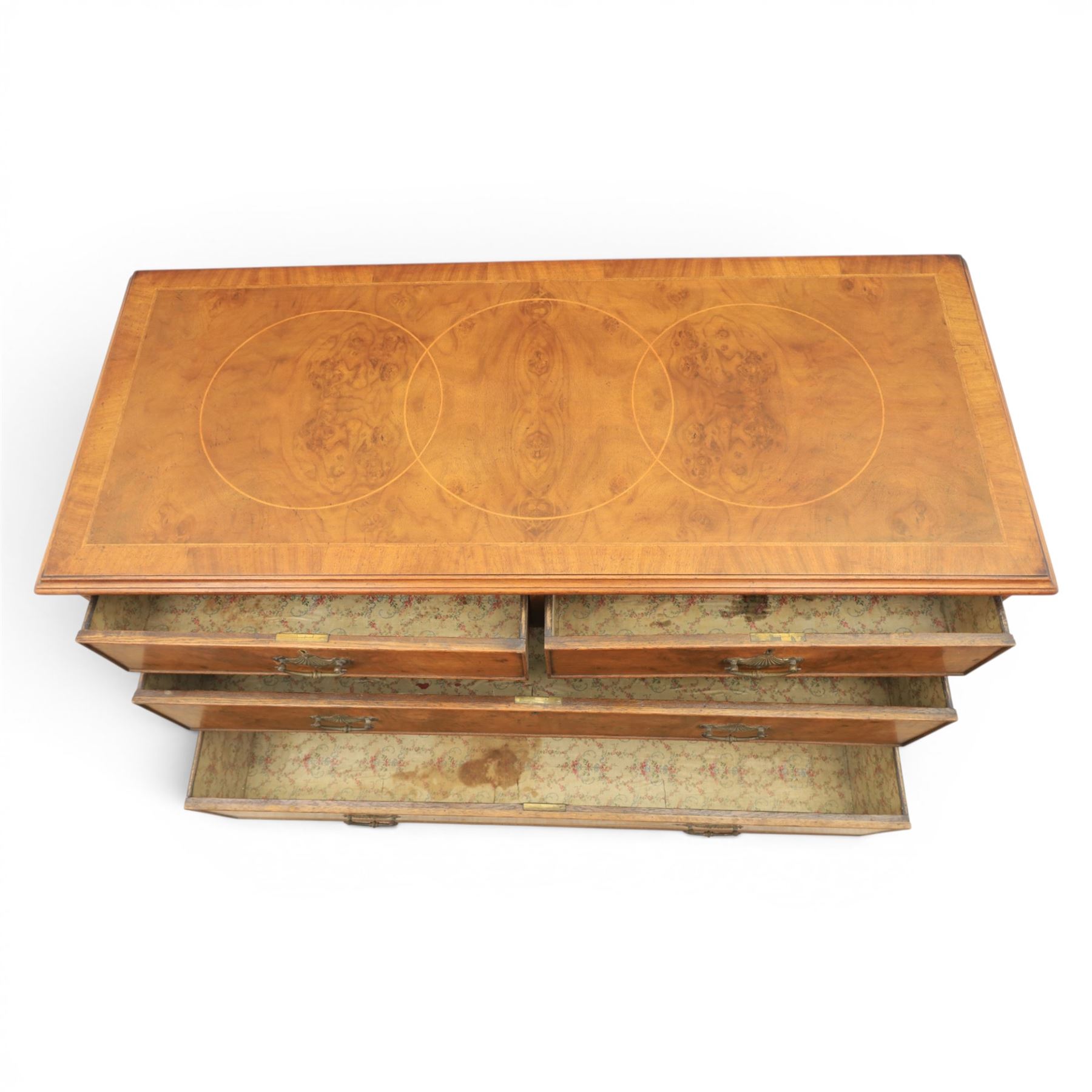 Traditional design walnut inlaid chest, with figured top with circular inlay and crossbanded top with moulded edge, figured drawers with cockbeaded edges and brass handles, raised on bracket feet