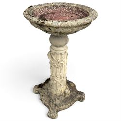 Weathered cast stone birdbath, the kylix shaped bowl with fluted body, raised on a fruitin...