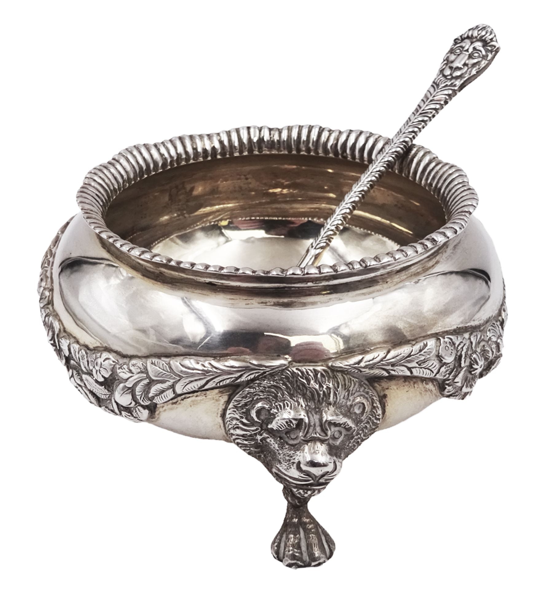 Early 20th century silver open sucrier, of circular form, with fluted gadrooned rim and decorated in relief with floral swags, united by three lion mask mounts and upon three paw feet, hallmarked Z Barraclough & Sons, London 1912, H6cm, D11cm, with similar spoon with lion mask finial, hallmarked London 1912, maker's mark indistinct