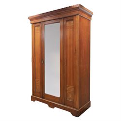 Aesthetic Movement walnut parcel gilt wardrobe, the crenellated top, above central mirrored door opening to reveal hanging space, four opened and two closed draws