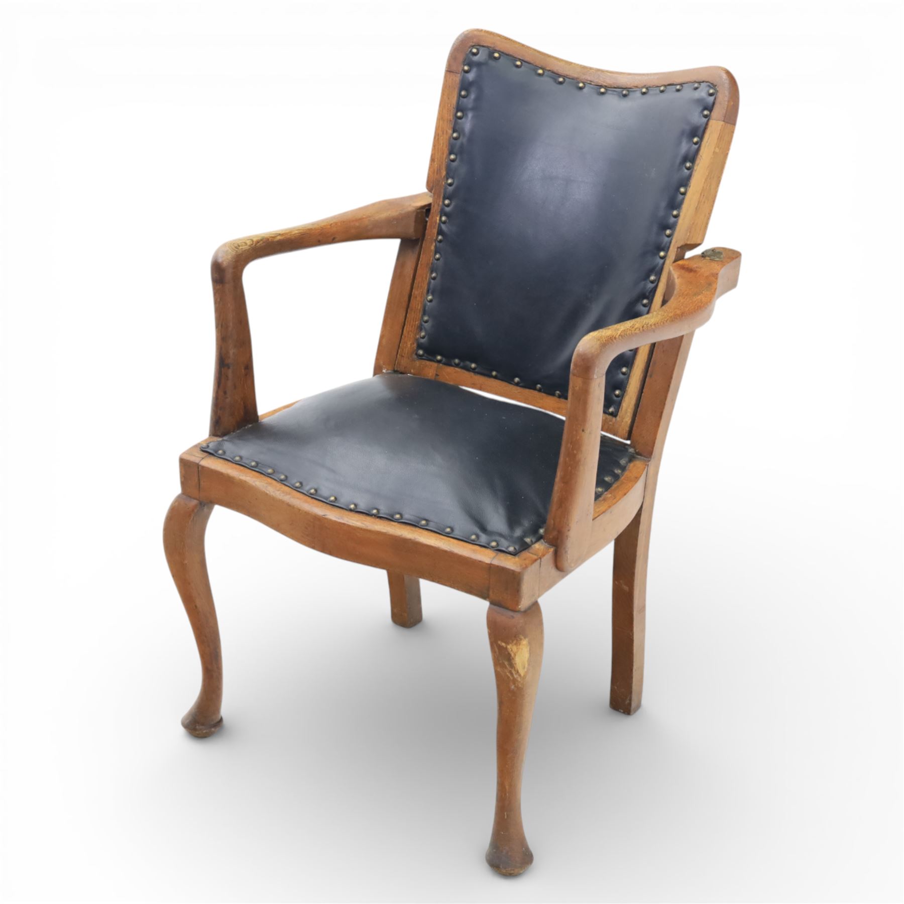 20th century oak recliner armchair, the curved back upholstered in leather with brass stud edging, hinged reclining back operated by side ratchet fittings, leather upholstered seat, shaped open arms, raised on cabriole legs