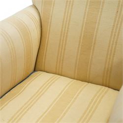 Early 20th century scroll arm armchair, upholstered in ivory striped cotton fabric with piped seams, sprung seat, on turned tapering front legs with brass caps and castors