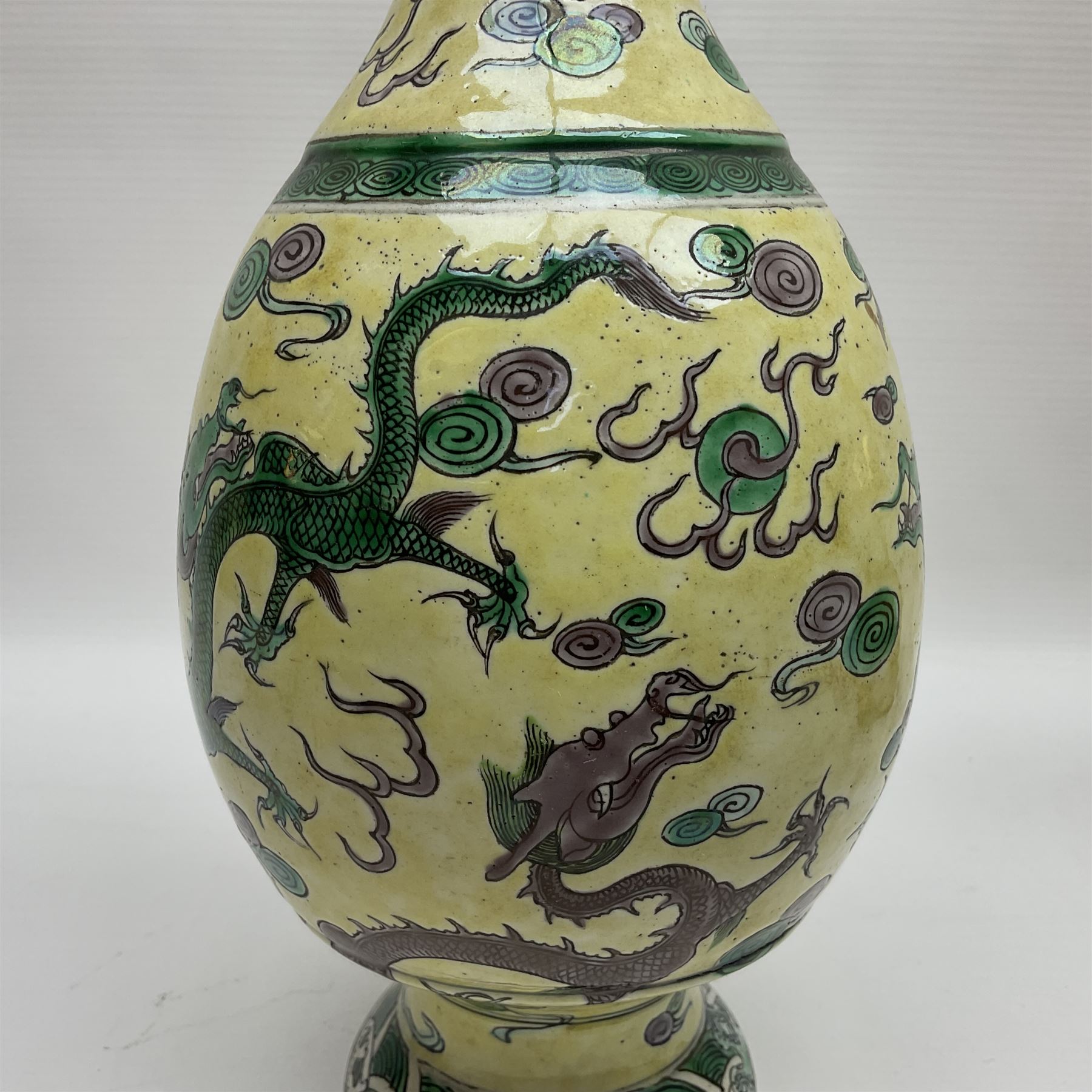 20th century Chinese Famille Verte vase, of slender ovoid form with tapering neck and flared rim, decorated with green and grey enamel with dragons chasing flaming pearls amongst auspicious clouds upon a yellow ground, H30cm