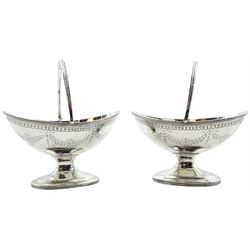 Pair of Victorian silver pedestal table salts, of navette form with swing handle, the bodies engraved with floral swags, hallmarked London 1878, makers mark worn and indistinct, not including handle H6.5cm L10.5cm, approximate weight 5.09 ozt (158.5 grams)