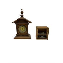 A German musical alarm clock (model 1523/24) made by the Hamburg Amerikanische Uhrenfabrik c1880, in an oak case with an architectural top and finial, two-part dial with a gilt centre, ivorine chapter and steel spade hands, with roman numerals and minute track, case raised on four bun feet, with a thirty-hour balance wheel pin pallet spring driven movement sounding the alarm on a musical movement, key wound and set from the rear. Compete with three different and changeable musical movements in their original box. These clocks would have been sold as here with separate musical movements, it is rare to find them with the original clock.
H30 W17 D11 

	



