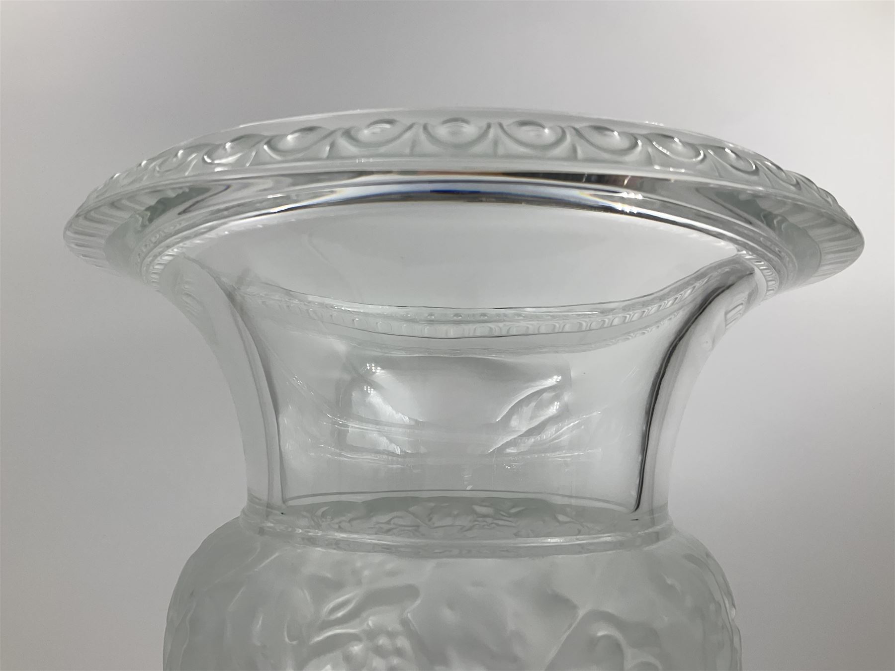 Large and impressive Lalique Versailles pattern glass vase, of classical baluster form with gadrooned flared rim, the body moulded in relief with fruiting vines above part fluting, upon a spreading circular foot with moulded decoration, and plain square plinth base, signed Lalique France to side of plinth, overall H35cm, with original box 