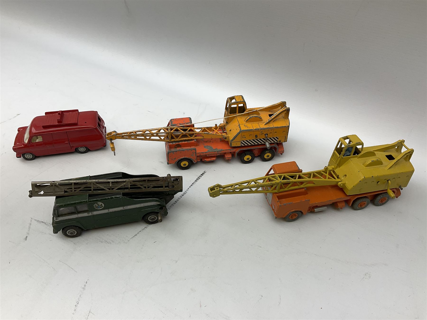 Dinky - thirteen unboxed and playworn die-cast commercial vehicles including two Supertoys 20-Ton Lorry-Mounted Cranes; Leyland Octopus Tanker; Fire Engine No.955; Extending Mast Vehicle No.969; two TV Roving Eye Vans No.968; three Ford Transit Vans; Brinks Armoured Car No.275; etc