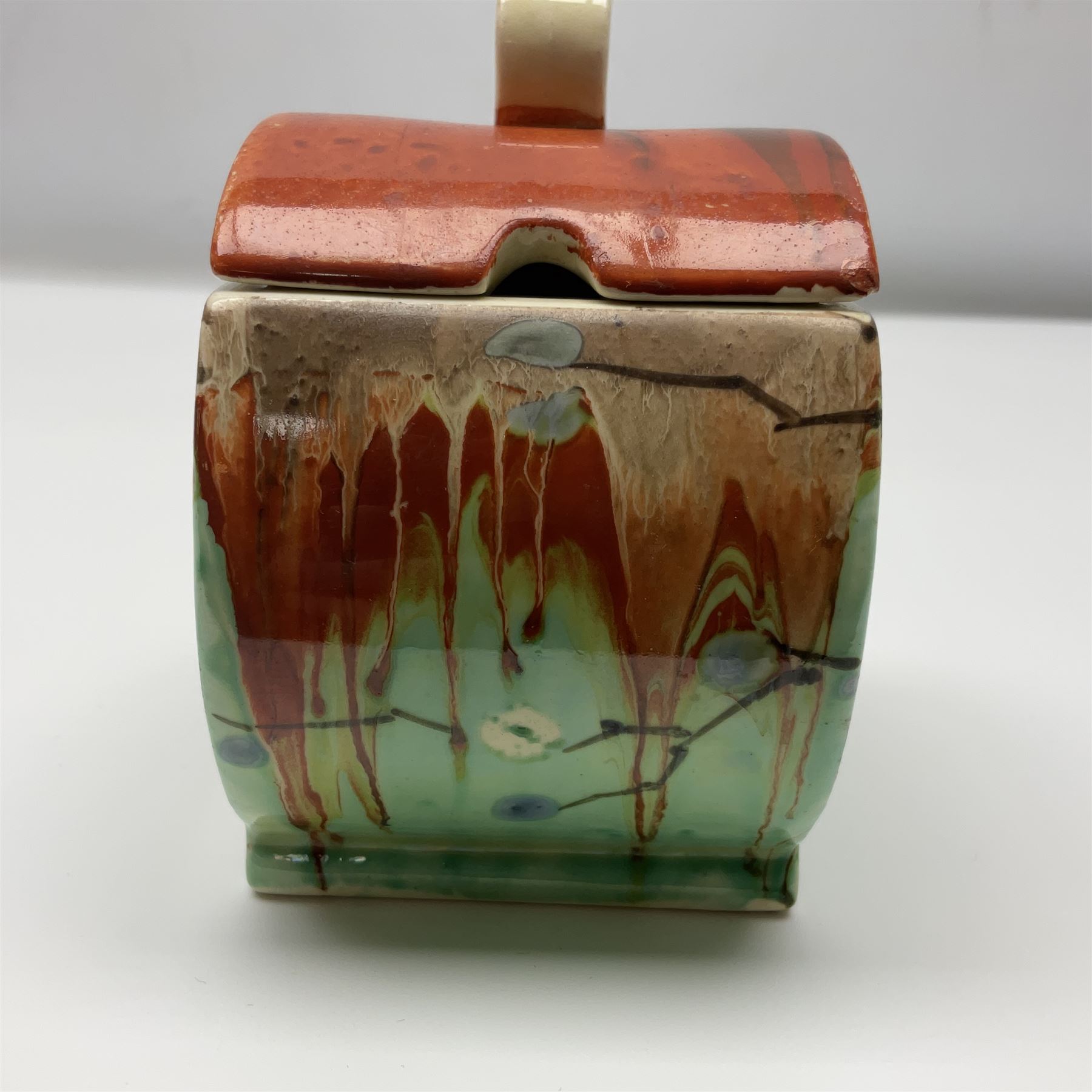 Clarice Cliff Bizarre for Wilkinson Pottery, Bon Jour shape preserve pot decorated in the May Blossom pattern, hand painted with stylised blossom upon a streaked merging green and orange ground, with conforming lift off lid, with black printed mark beneath, H10cm