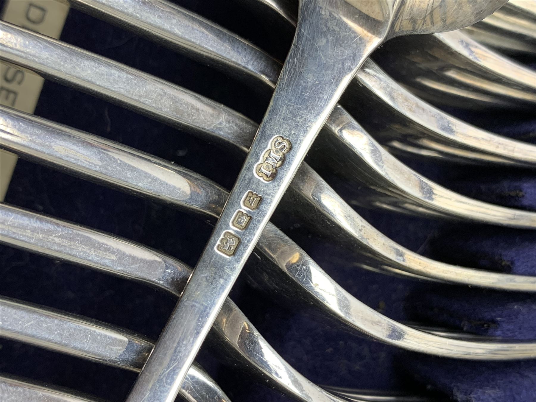 Late 19th/early 20th century composite canteen of silver flatware, contained within an early 20th century mahogany serpentine fronted case with twin drop carry handles, and hinged cover with boxwood stringing and central inlaid shell motif, above a single drawer with twin ring handles and Wellington style locking system, the cover and drawer opening to reveal plaque for Spink & Sons Ltd London, and fitted interior containing ivory handled knives, ivory handled carving set, and silver Hanoverian and Old English pattern cutlery, each with engraved monogram to terminal, hallmarked London, makers Spink & Son (John Marshall Spink), Goldsmiths & Silversmiths Co, and Chawner & Co (George William Adams), various dates ranging 1880-1923, gross weighable silver 92.59 ozt (2880 grams)