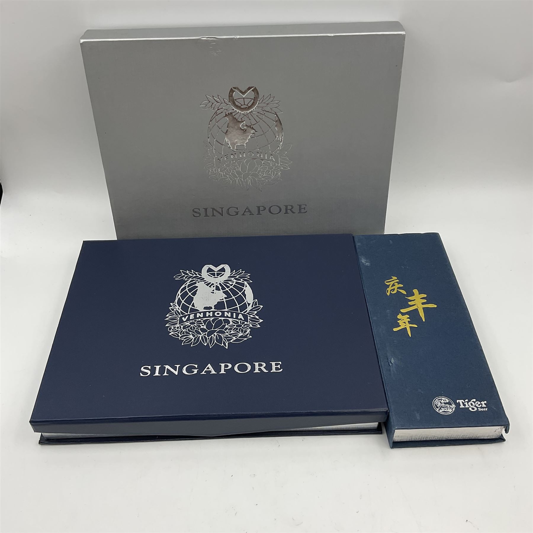 Singapore Venhonia commemorative medallion collection and a Tiger Beer commemorative three-medallion collection, both cased with certificates