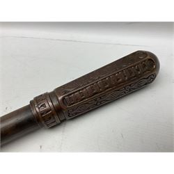 Native war club, the plain circular hardwood shaft with curving end and applied heavy copper tapering octagonal terminal cast with rows of stylised motifs L76cm