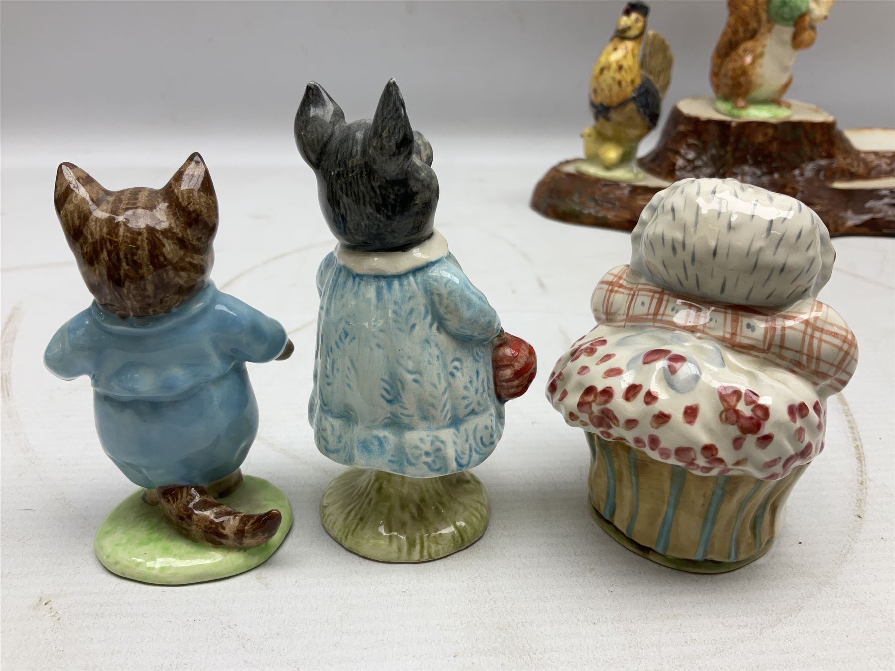 Seven Beswick Beatrix Potter figures, comprising Sally Henny Penny, Johnny Town-Mouse, Mrs Tiggy-Winkle, Mrs Tittlemouse, Tom Kitten, Pig-Wig and Squirrel Nutkin, together with a Beswick tree trunk display stand, stand L30cm