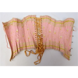  Early 20th century French pink silk corset/ stay, whalebone supports, lace edging and embroidered floral sprigs, metal grommets/ eyelets  