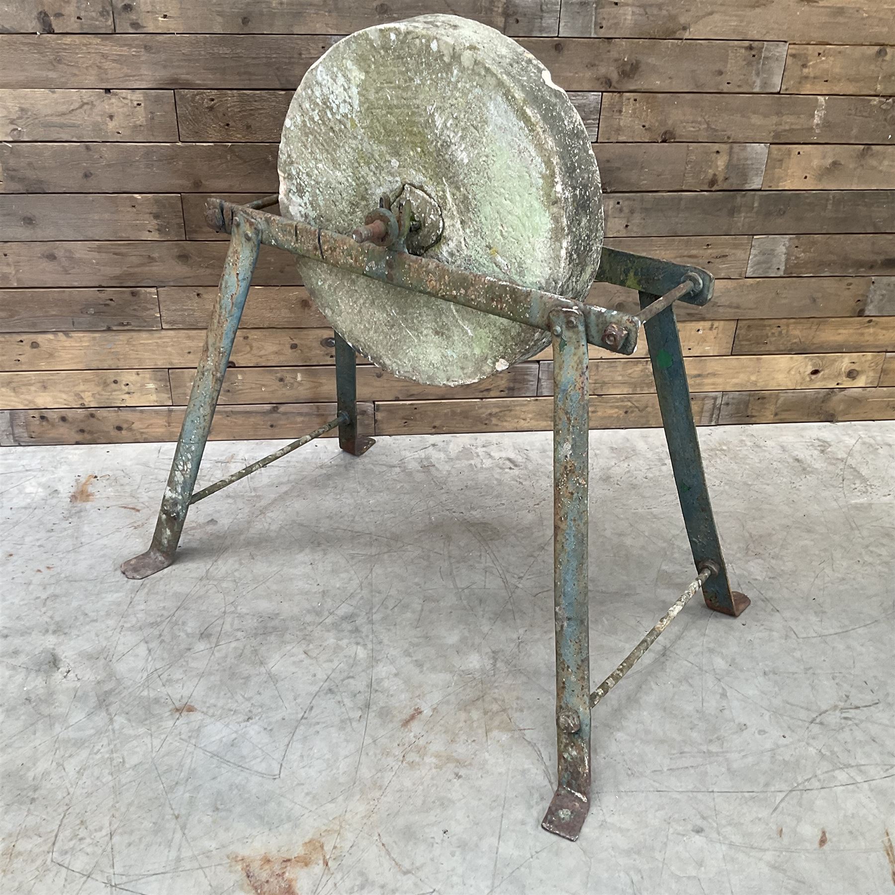Vintage grindstone sharpening wheel mounted on metal stand, and a cast iron water pump