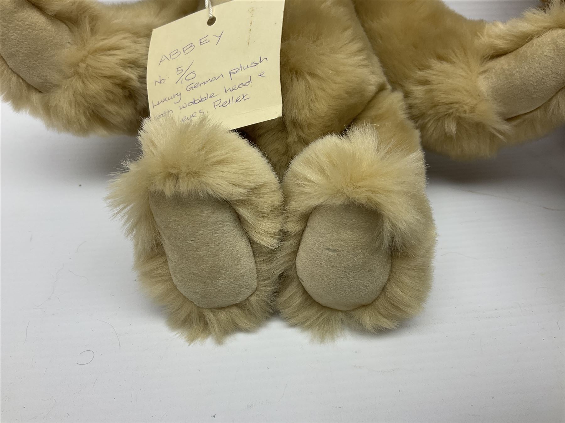 Group of five teddy bears comprising ‘George’ a unique pellet filled bear with glass eyes and velvet paws H38cm, and ‘Abbey’ a luxury German plush with wobble head and glass eyes no.5/10 H24cm, both with Teddies from Bearyland labels; along with two light blonde mohair H. M. Bears and Boyds Bears ‘T. F. Wuzzies’ no. 595140 (5)
