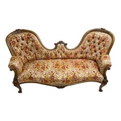 Victorian walnut double ended settee, the shaped and moulded cresting rail carved with fruit and foliage, upholstered in floral pattern fabric, scroll carved arm uprights and supports 