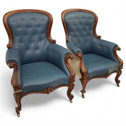 Fine pair of mid-19th-century mahogany library armchairs, carved frame with balloon-shaped back with scrolled ends, rolled wide arms, ending in a scrolled volute above a serpentine seat rail, upholstered in mottled turquoise faux leather, button upholstered back, arms, and cushion seat, studded sides and apron, raised on scroll carved front feet and splayed rear legs on castors 