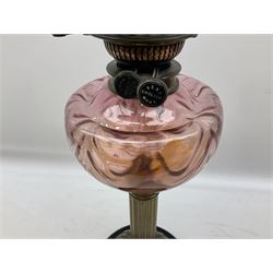 Victorian table oil lamp with black glazed stepped circular base, reeded brass column, moulded pink glass reservoir, duplex burner and frilled rim frosted glass shade with clear glass chimney H69cm