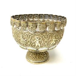 An Eastern white metal bowl, with pierced rim above a central embossed band of zoomorphic figures, and alternating lobed panels of animals and flowers, upon a circular spreading foot, H19cm D22cm. 