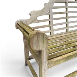 Lutyens design weathered teak garden bench with matching two-tier table, the bench with shaped arched and slatted back over rolled arms and slatted seat