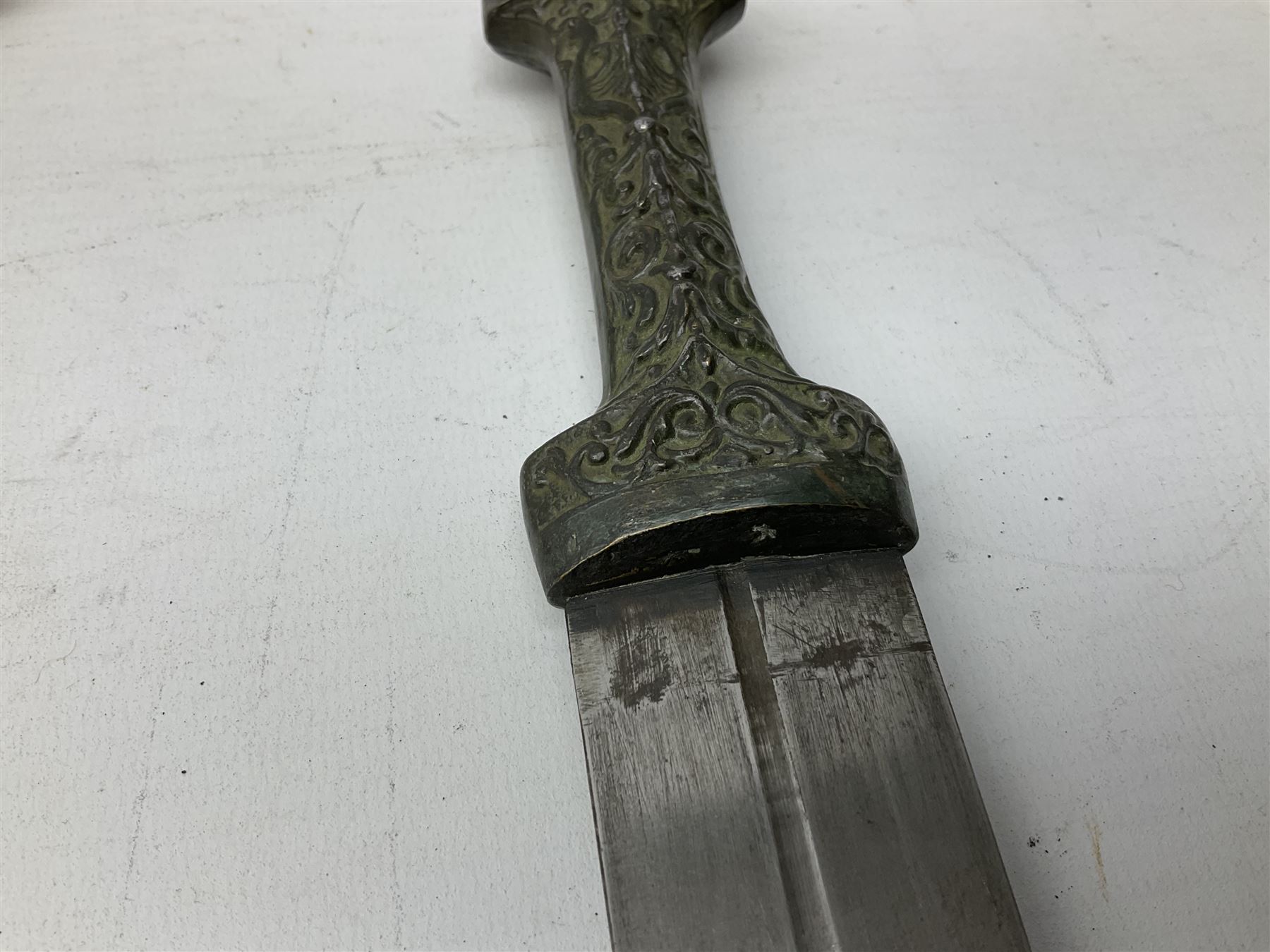 19th century Khanjali dagger, 33.5 cm double edged fullered blade with stamped makers marks, ornate cast grip, with engraved white metal scabbard, 46cm overall