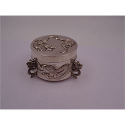 Late 19th/early 20th century Chinese export silver box, of circular form, the body and removable cover decorated in relief with circling dragons, upon three dragon head feet, stamped beneath with character mark, 90 and WH for Wang Hing, H6.5cm, D9cm
