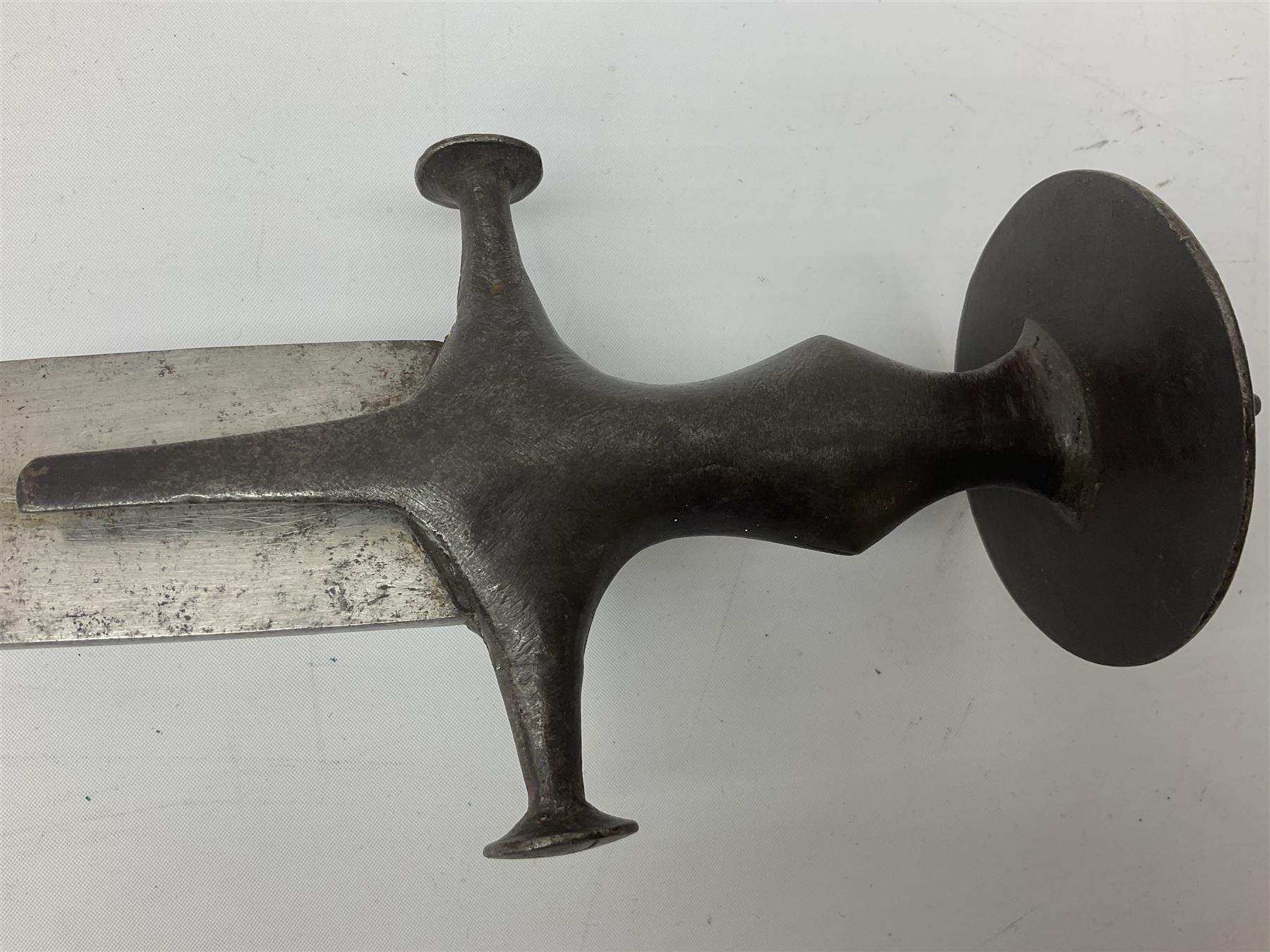 19th Century Indian Tulwar sword with 77cm single edged, slightly curved fullered blade;  steel crossguard, langets, grip and spiked disc pommel with stiff leaf decoration L90cm overall