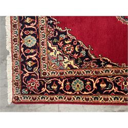 Persian Kashan rug, red ground field decorated with central floral medallion and matching spandrels, the guarded border with scrolling design decorated with stylised flower heads