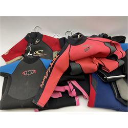 Collection of children's wet suits, including Odyssey Core long wet suit size 4/5 years, three Banana Bite short wet suits sizes 5 to 13 years and five other short wet suits.  