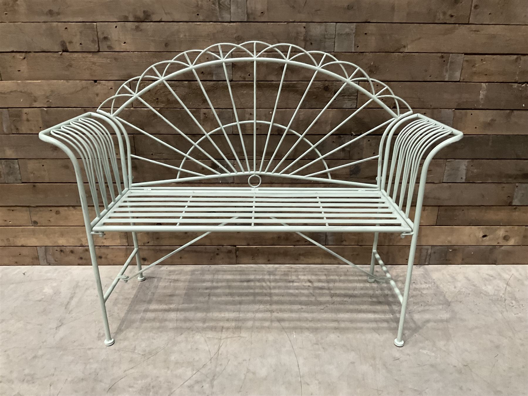 Wrought metal two seat garden bench, sunburst back, painted in pale green finish