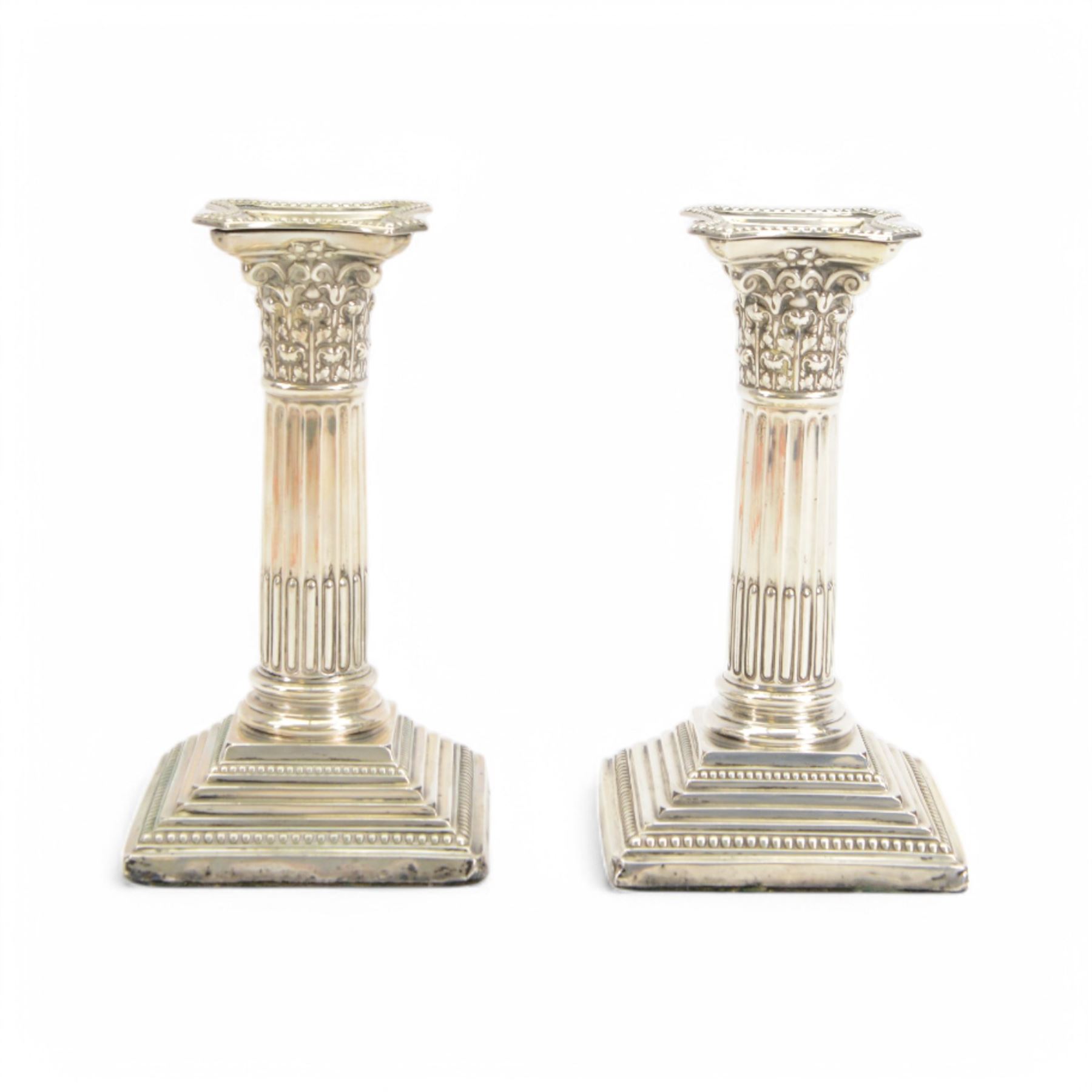 Pair of early 20th century silver Corinthian column candlesticks, upon square stepped filled bases, hallmarked Walter Latham & Son, Sheffield 1913, H16cm