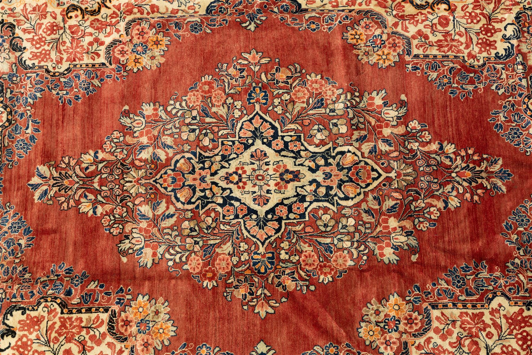 West-Central Persian Mahal hand-knotted carpet, terracotta field with a large central indigo and ivory medallion with floral palmettes and scrolling vines, framed by ivory spandrels with dense foliage within a broad navy border of lotus and palmette motifs linked by scrolling tendrils and multiple guard stripes 