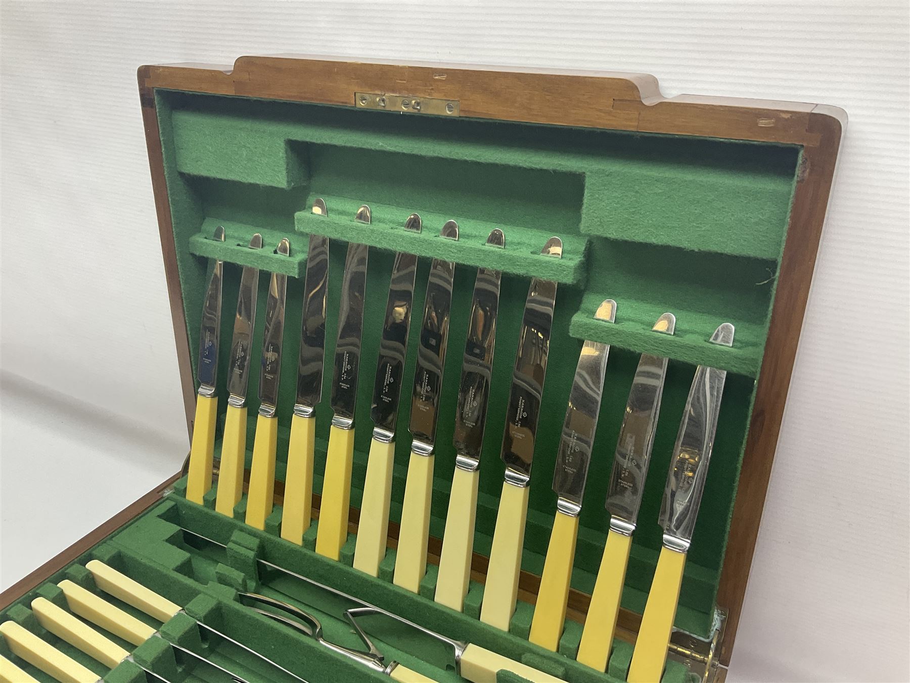 Art Deco canteen of silver plated cutlery for twelve place settings, including table and dessert knives with ivorine handles, retailed by Harrods Ltd, contained within a wooden case, with drawer to base, canteen case H15.5cm