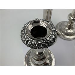 Four George III silver candlesticks, each upon knopped stem and weighted circular stepped foot, the foot and removable sconce repousse decorated with a band of flower heads, hallmarked to sconce and foot Thomas & John Settle, Sheffield 1820, H17.5cm