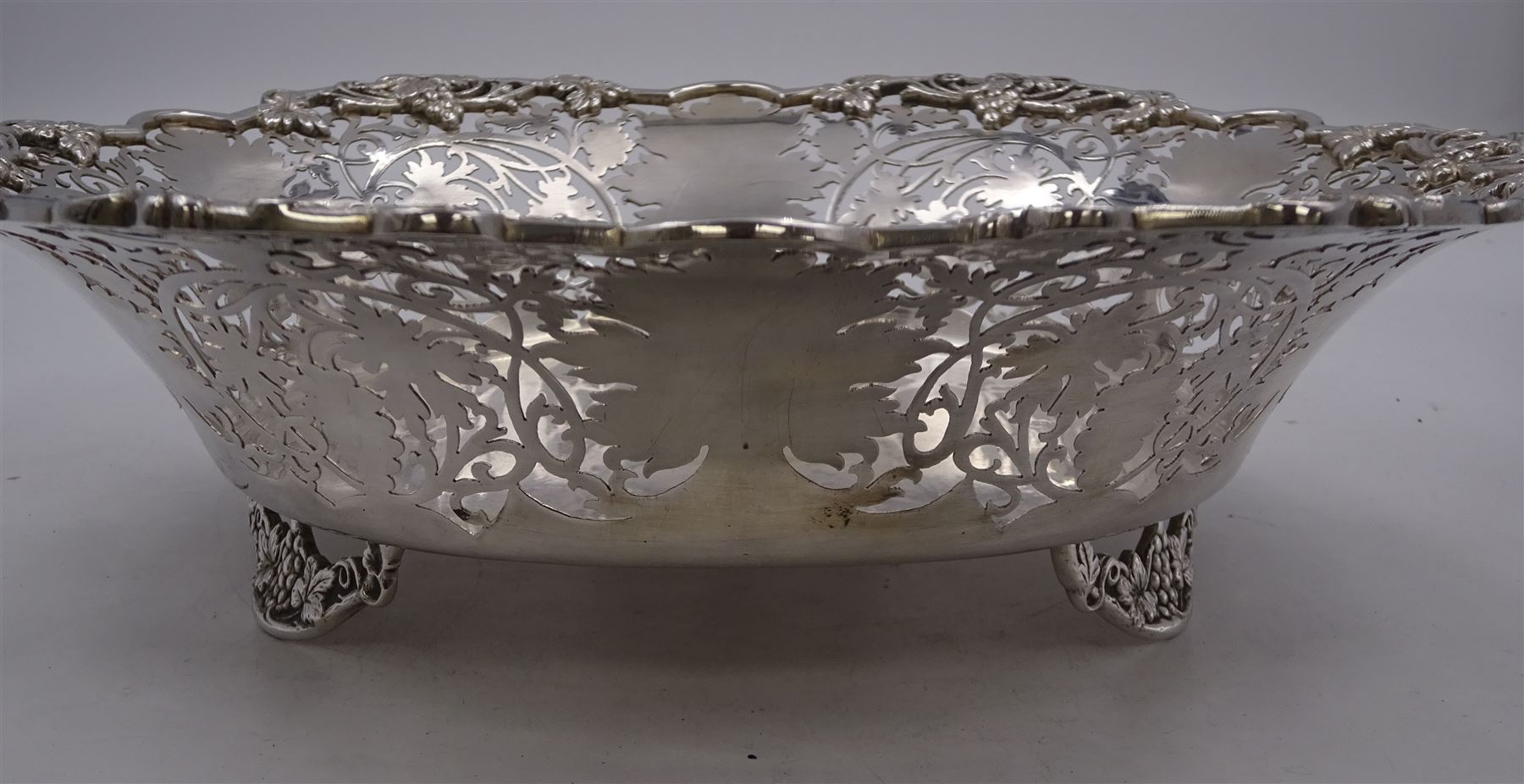 Modern silver Britannia standard fruit bowl, of lobed circular form, with applied and pierced fruiting vine decoration throughout, upon three bracket feet, hallmarked 1966, maker's mark BSC