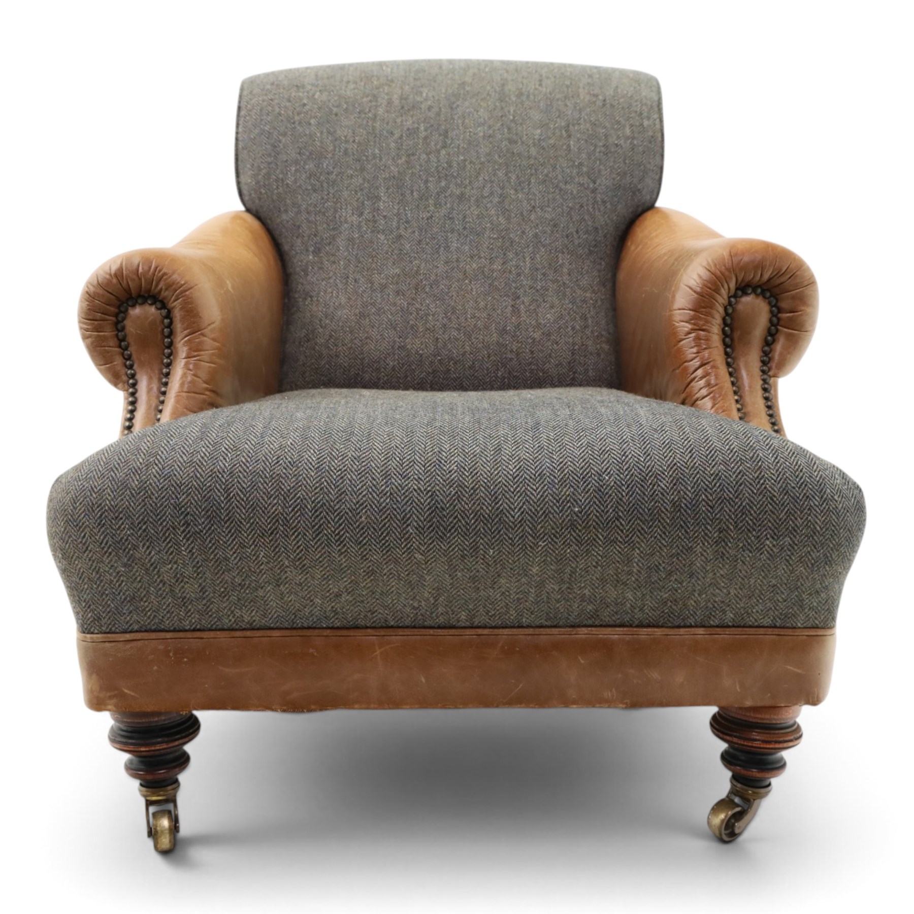 Tetrad - 'Taransay' Harris Tweed and tan leather club armchair, Howard shape with reclined back over deep seat and rolled arms with studwork, raised on turned front supports with castors, the sides and arms upholstered in tan leather with seat and back in herringbone-stitched Harris Tweed