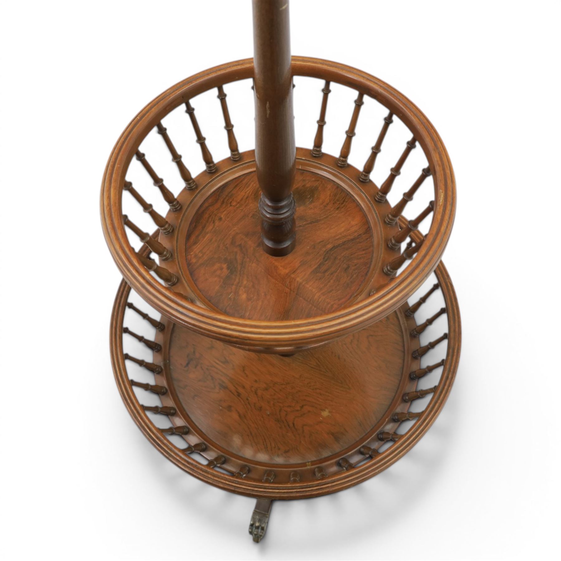 Regency style oak two-tier dumb waiter, with turned finial above central column support, two circular spindle-galleried basket tiers, raised on downswept tripod supports with brass caps and castors