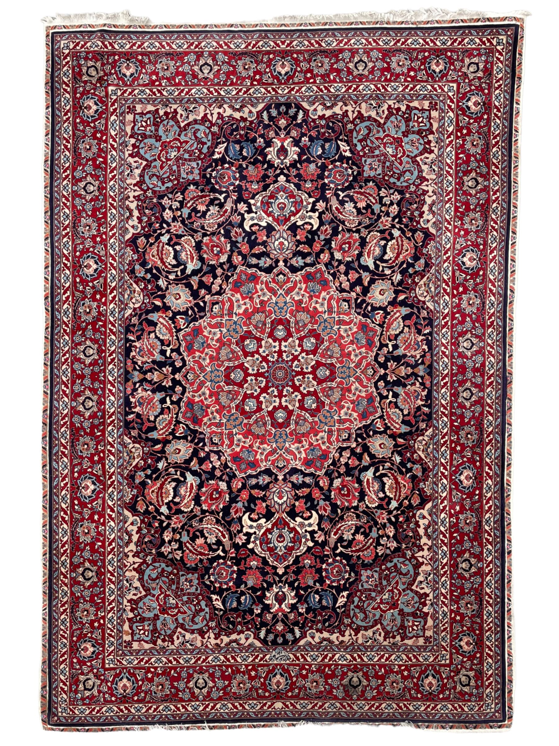Persian Hamadan indigo ground rug, central floral crimson pole medallion surrounded by trailing foliate decoration and stylised plant motifs, the main guarded border with repeating stylised flower heads, densely knotted
