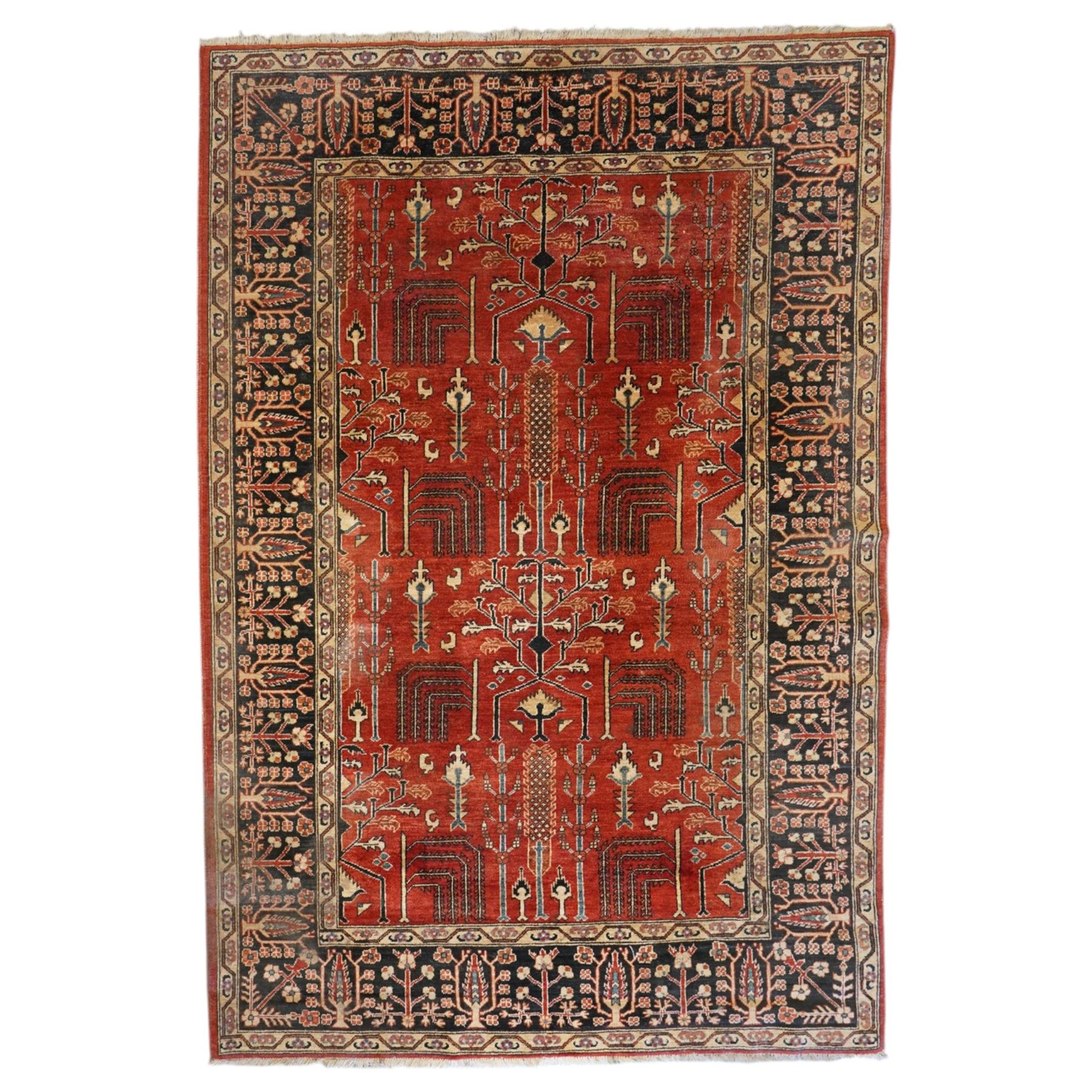 Anatolian crimson ground tribal rug, the field decorated with repeating geometric tree of life motifs with figural designs, the indigo guard band with stylised palmettes