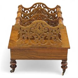 Victorian walnut Canterbury, scroll pierced divisions with turned carrying handles above a frieze drawer with knob handles, raised on turned legs terminating in brass castors