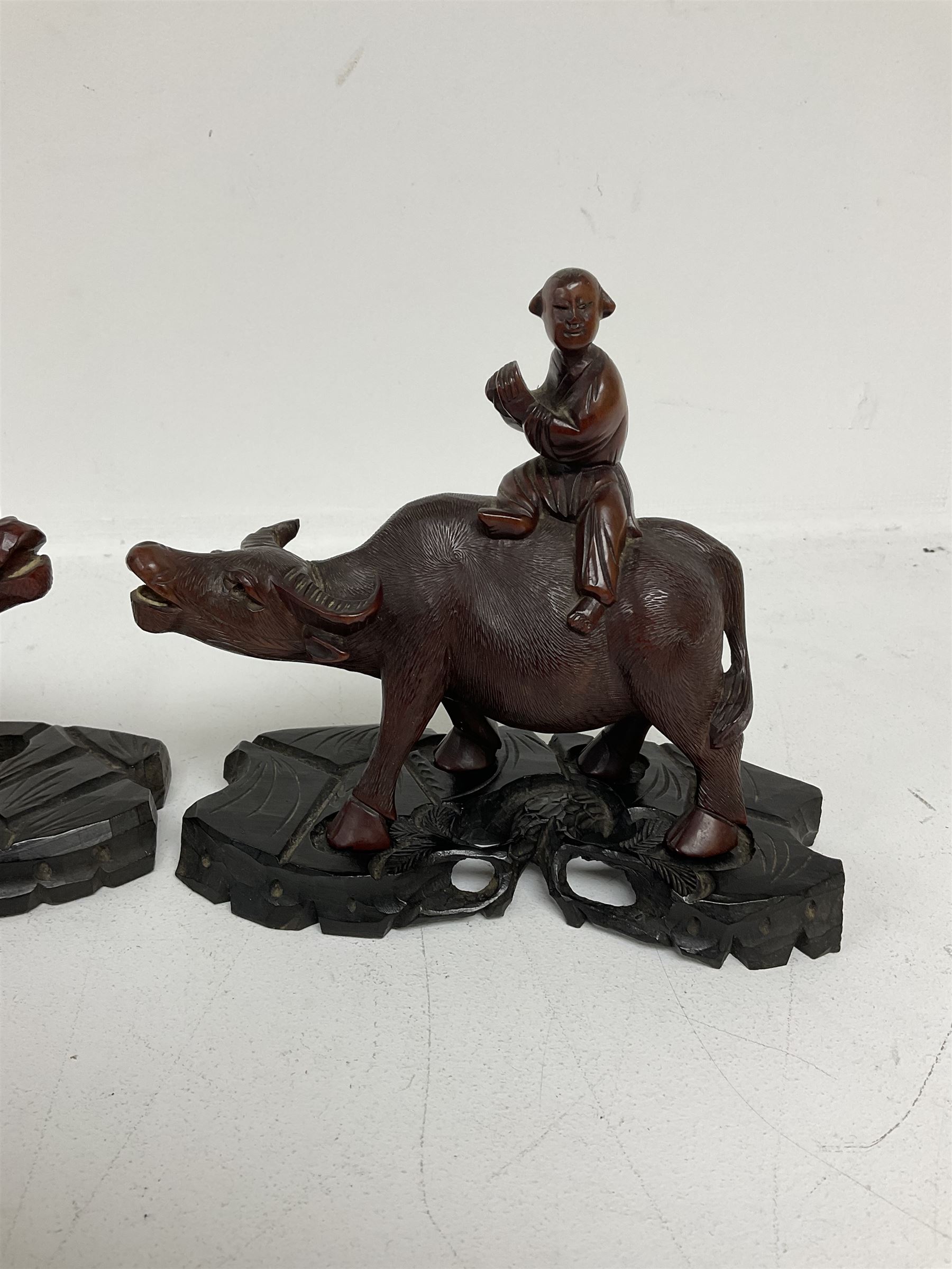 Pair of Chinese hardwood figures of farmers riding water buffalo, on stands, H19cm