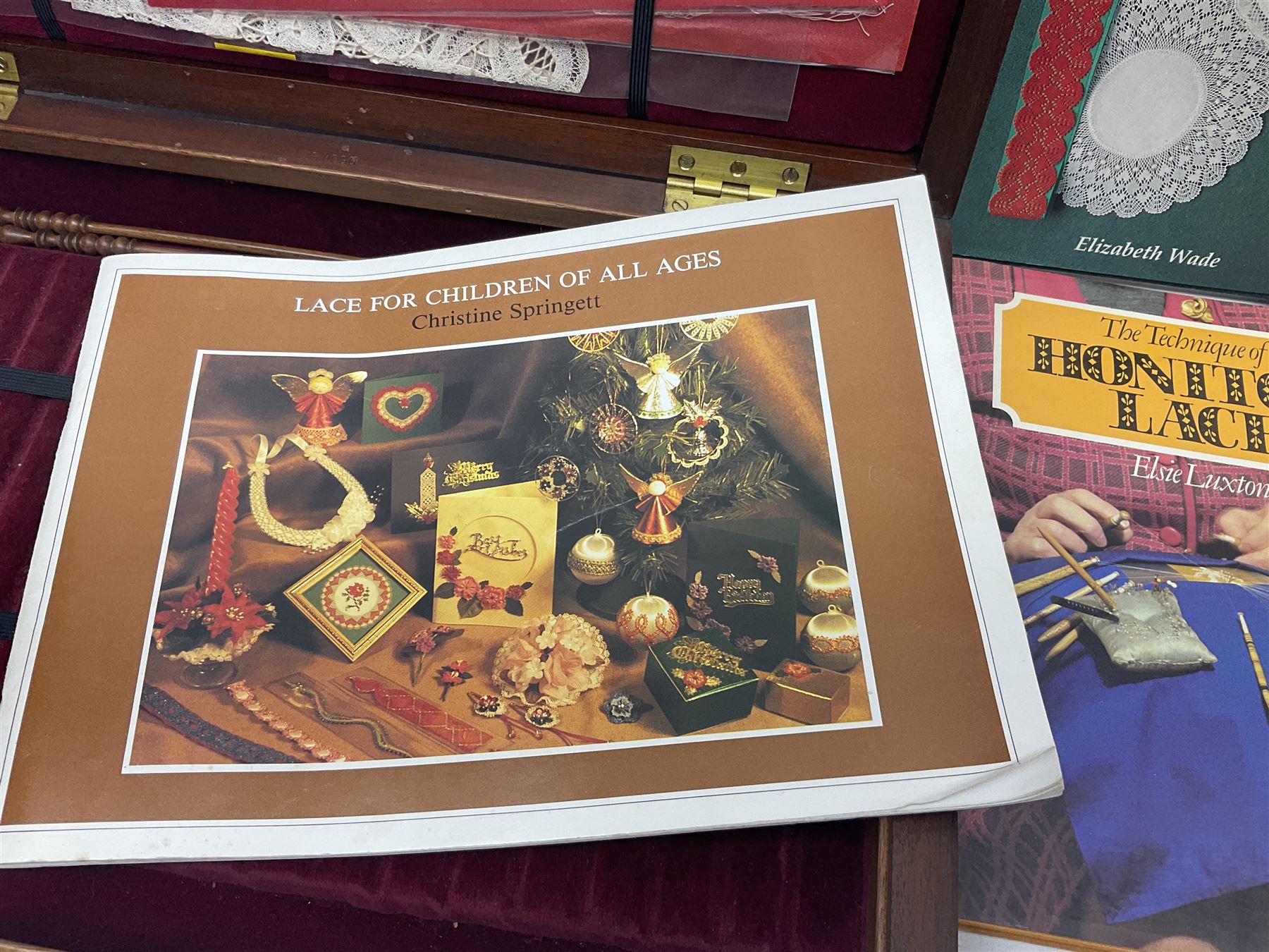 Collection of lace making wooden bobbins, together with lace making books and a handmade storage box