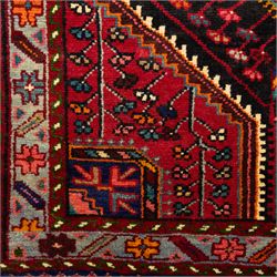 North west Persian Koliahee hand-knotted rug, central magenta field with elongated hexagonal medallion and arrow-shaped pendants over a dark lozenge-filled panels and stepped spandrels filled with boteh and floral motifs, corner square and cruciform devices within a pale olive border of stylized rosettes and angular vines between narrow guard stripes 